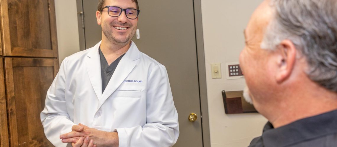 Dr. Vickers smiling at a wisdom tooth removal patient after he has told him how to avoid getting dry socket.