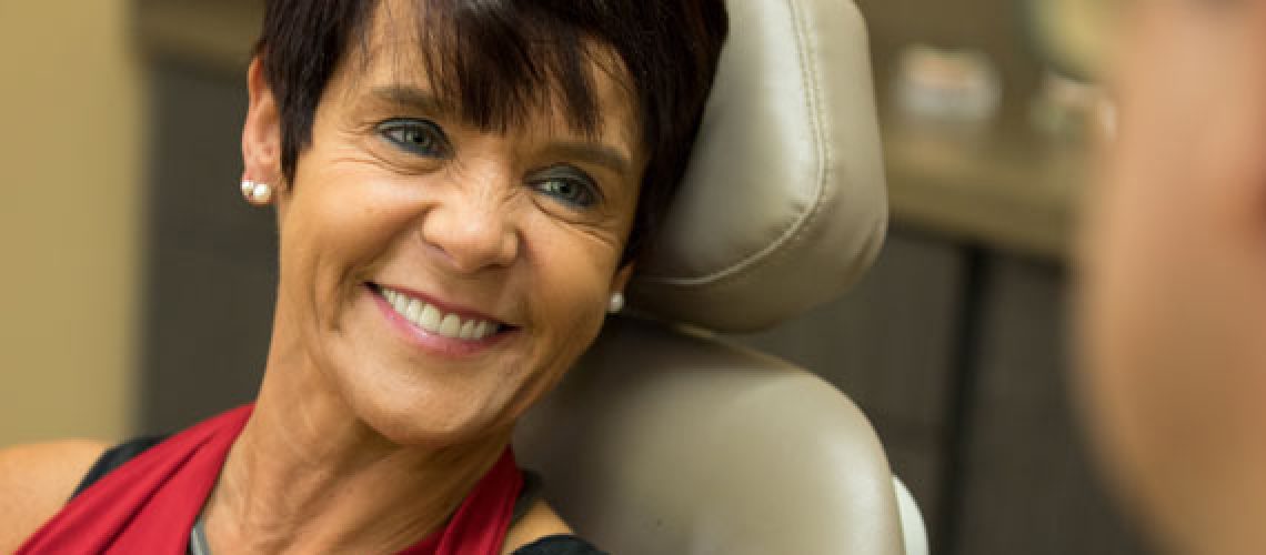 a dental patient smiling with full mouth dental implants.